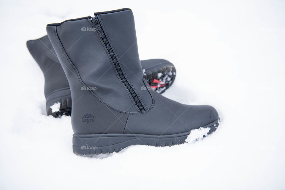 Close-up of a pair of women's winter boots in the snow