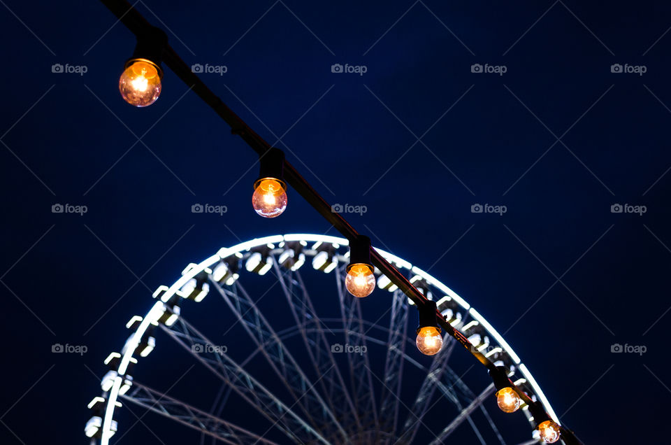 Lightbulb and a Ferris wheel at night 