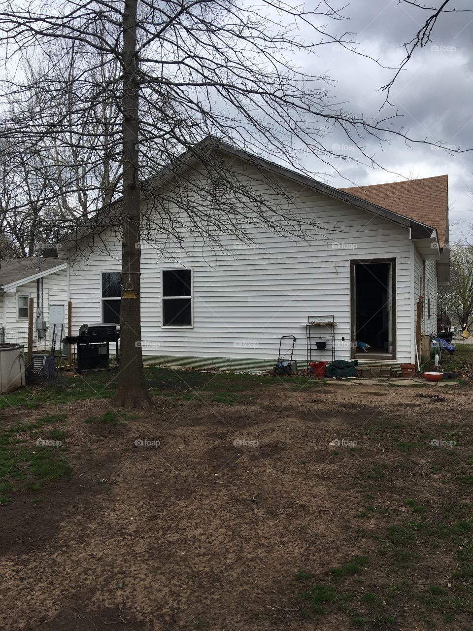 The back side of my house on a cloudy day. Tree hasn’t got its leaves back yet still early spring.