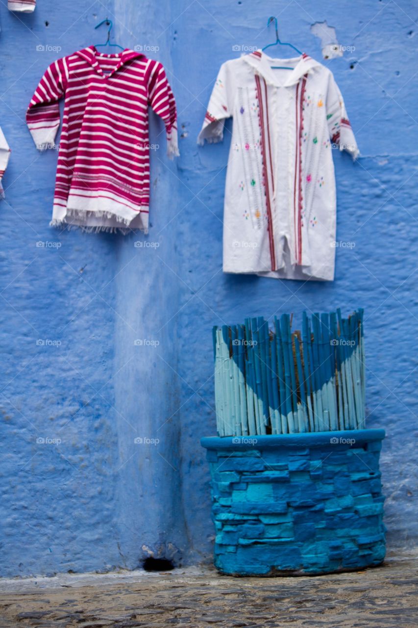 Clothes hanging against blue wall
