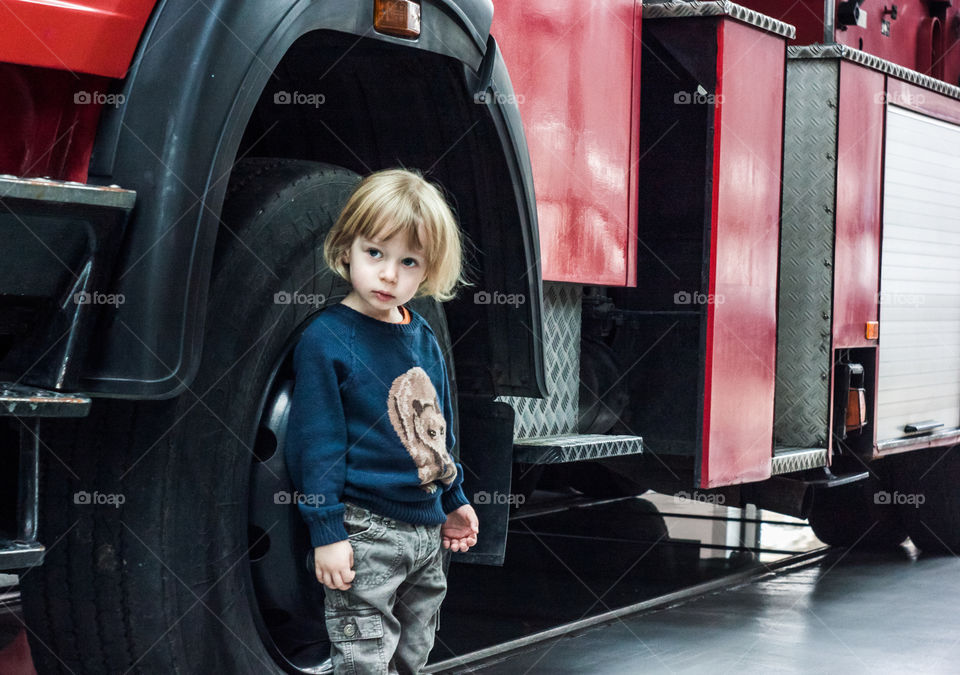 A boy standing in front of fire truck