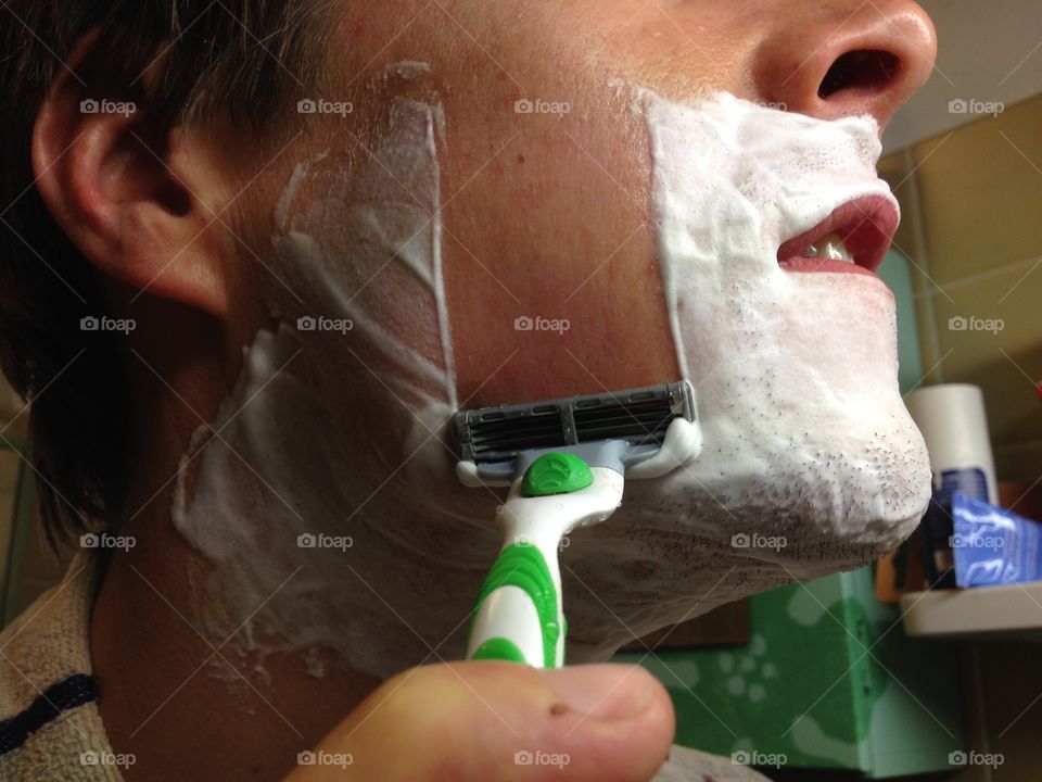 Close-up of a man shaving in the morning.