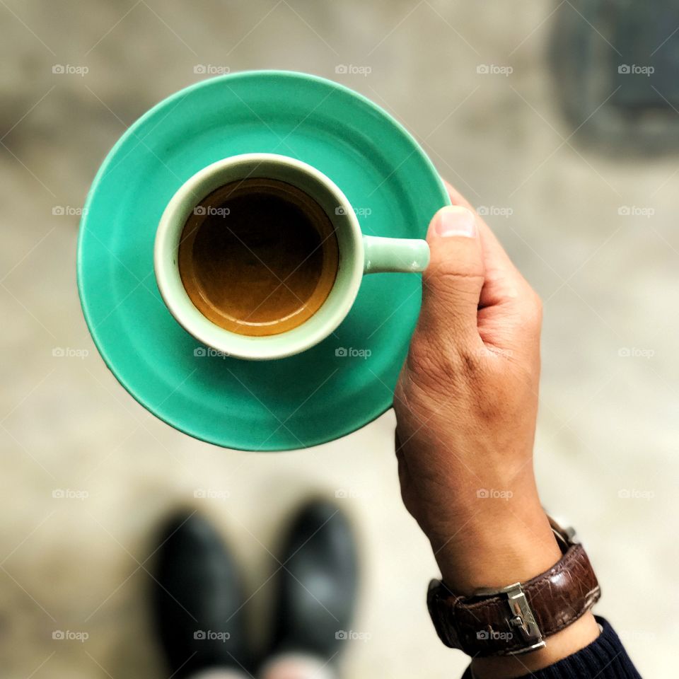 Human hand holding cup of coffee