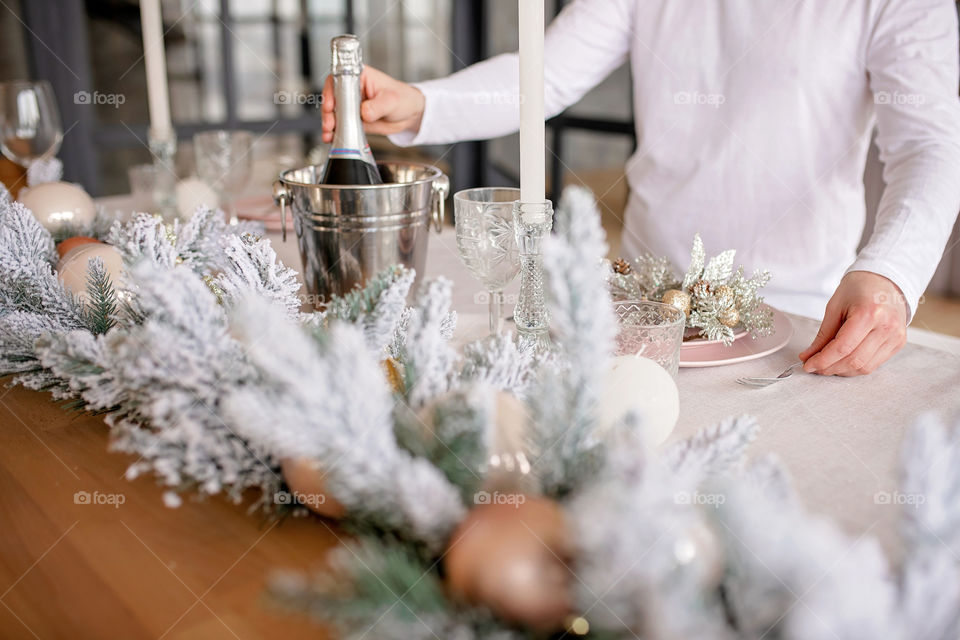 man sets a beautiful decorated winter table for a festive dinner.  Merry Christmas and Happy New Year.