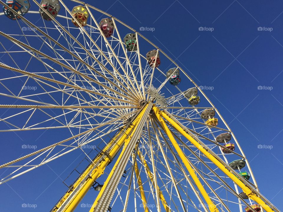 Low angle view of fairy wheel against blue sky