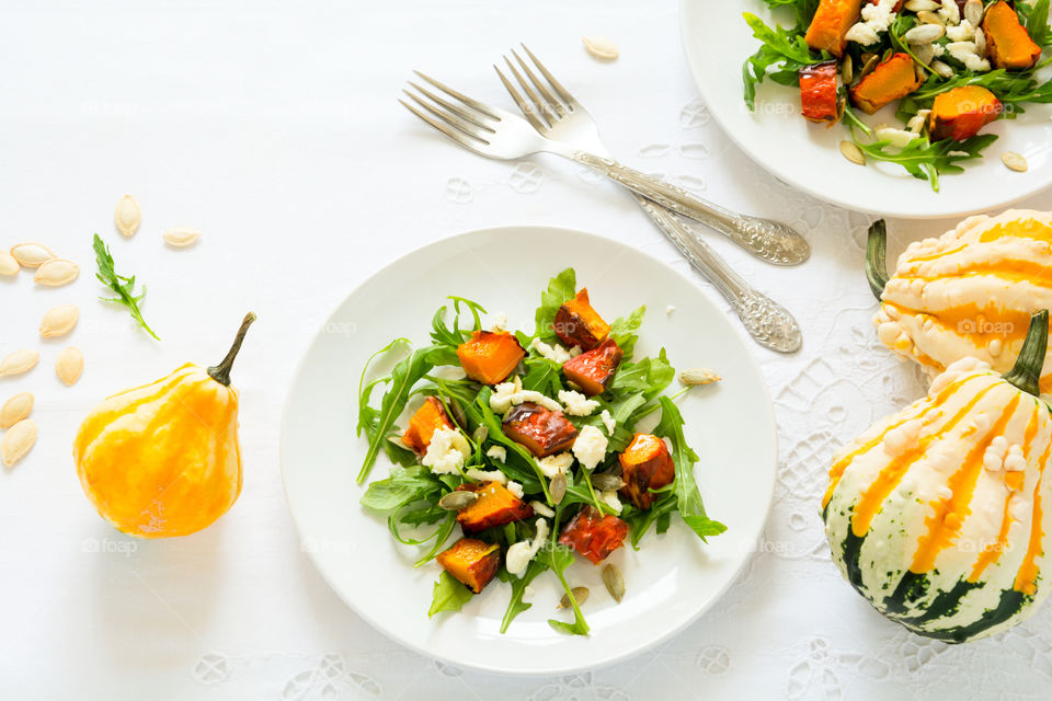 Autumn salad with arugula, cheese, baked pumpkin and seeds