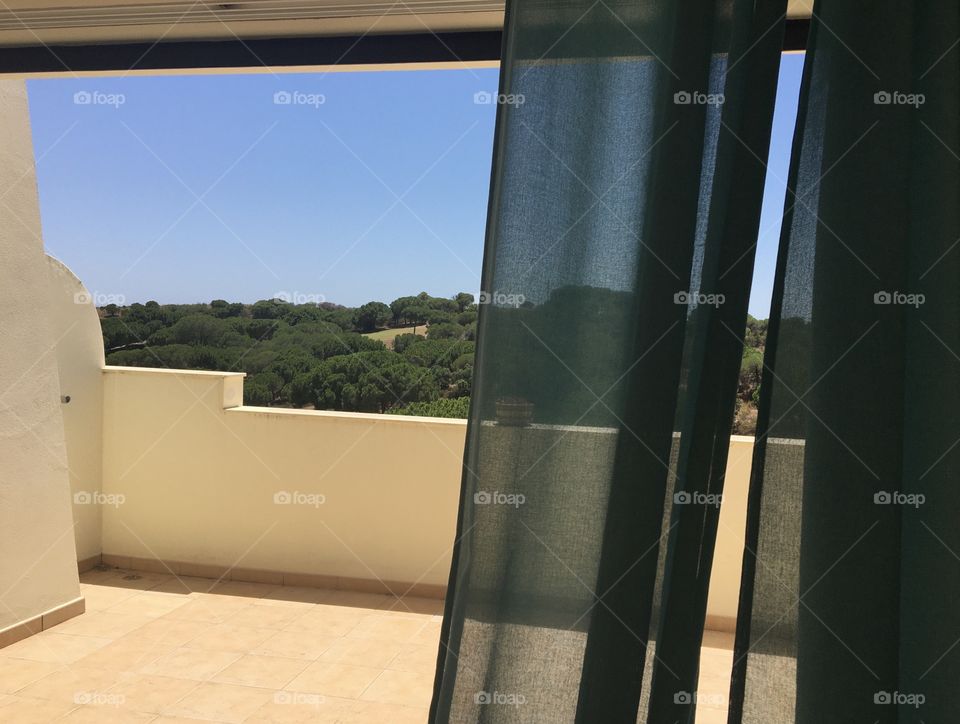 Open window on summer terrace and pines