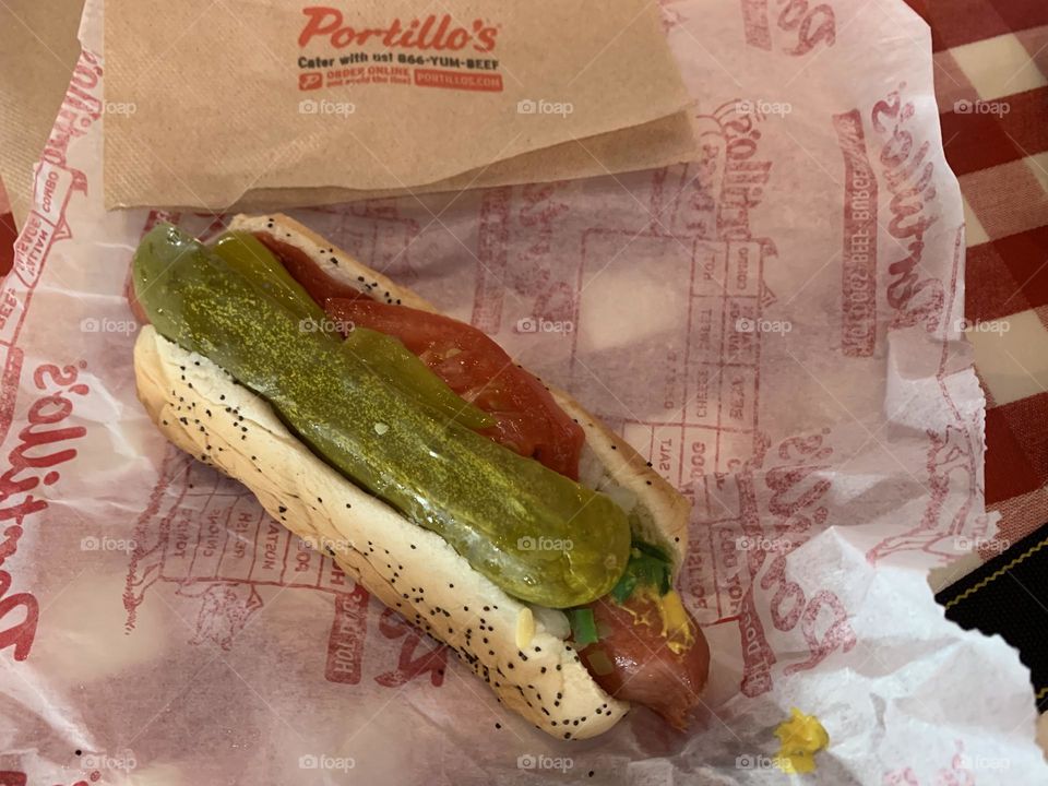 Chicago style dog - it starts with a steamed poppy seed bun and an all-beef frankfurter topped with yellow mustard, bright green relish, fresh chopped onions, juicy red tomato wedges, and a kosher-style pickle spear