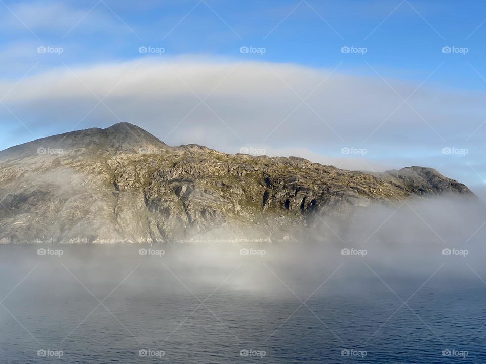 A mountain with a few wispy clouds 