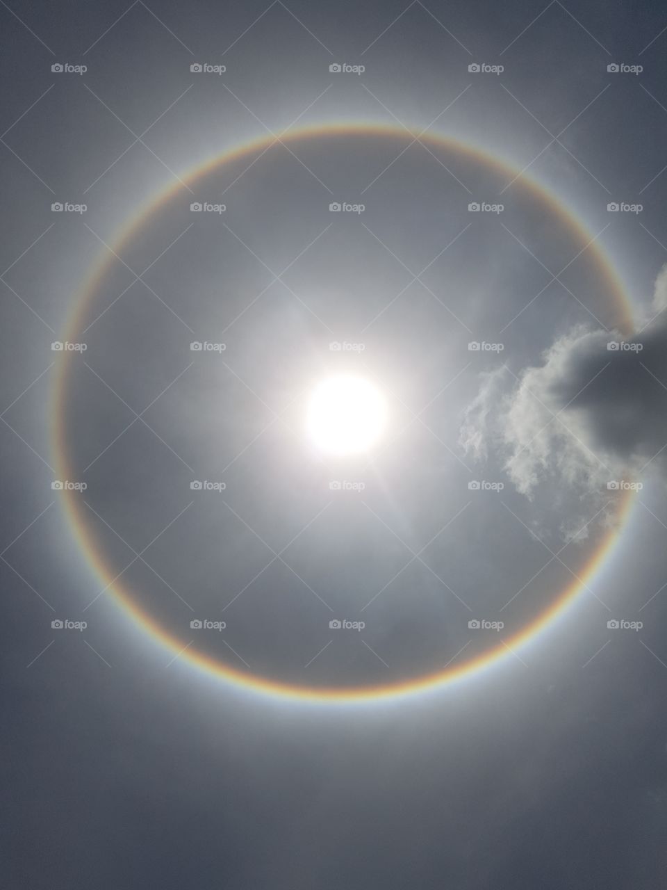 circle rainbow aura full spectrum around the sun in the sky
