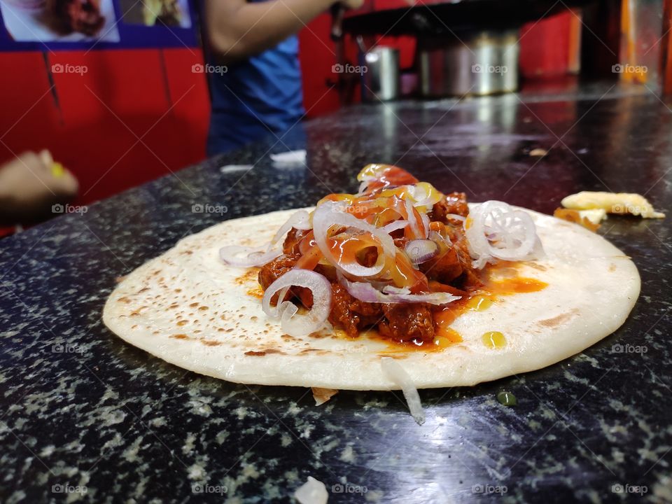 Indian food is known for spicy and diversity.North Indian Street food - Kolkata cutti roll is Indian bread packed with spicy chicken curry, sauce and onions wrapped with omlet