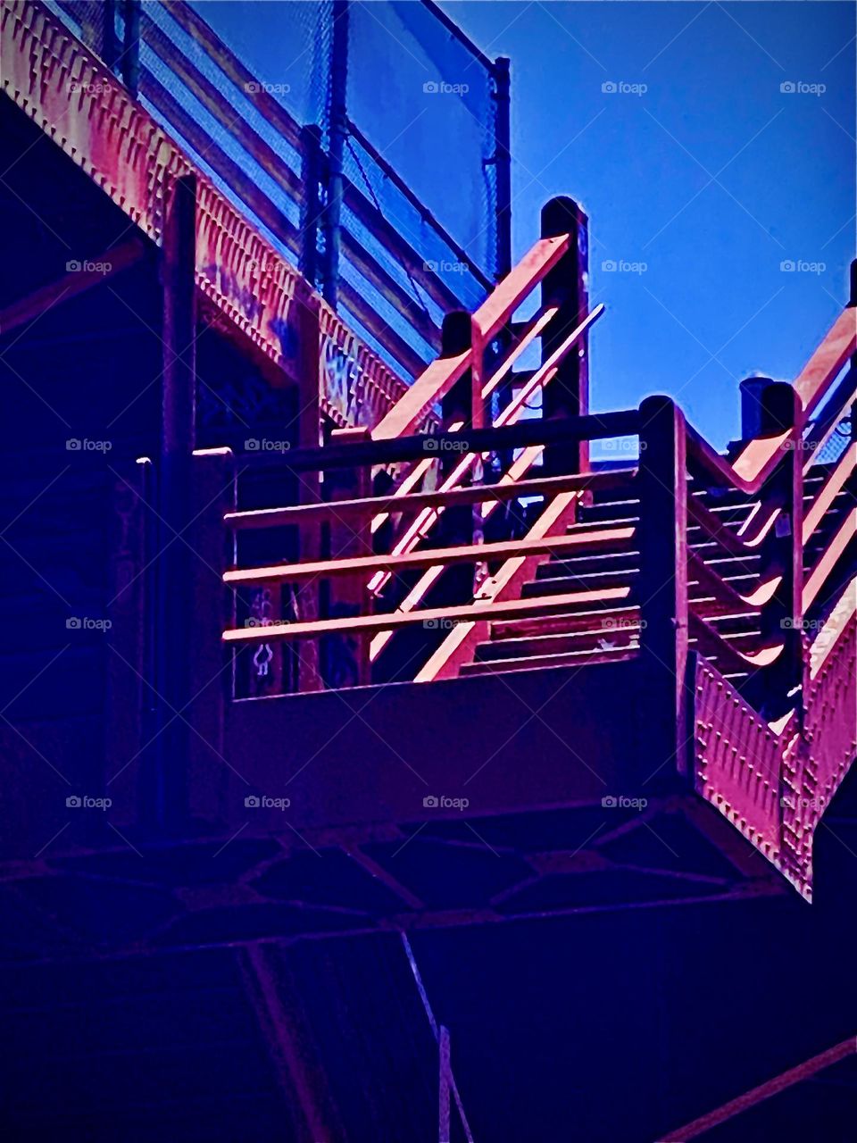 The red metal staircase goes up to the „Pulaski Bridge“ in LIC, Queens that leads to „Greenpoint“, Bklyn. It’s a prime example of urban industrialist design that is functional & practically oriented but also attractive. 2022. Hypnotic Productions