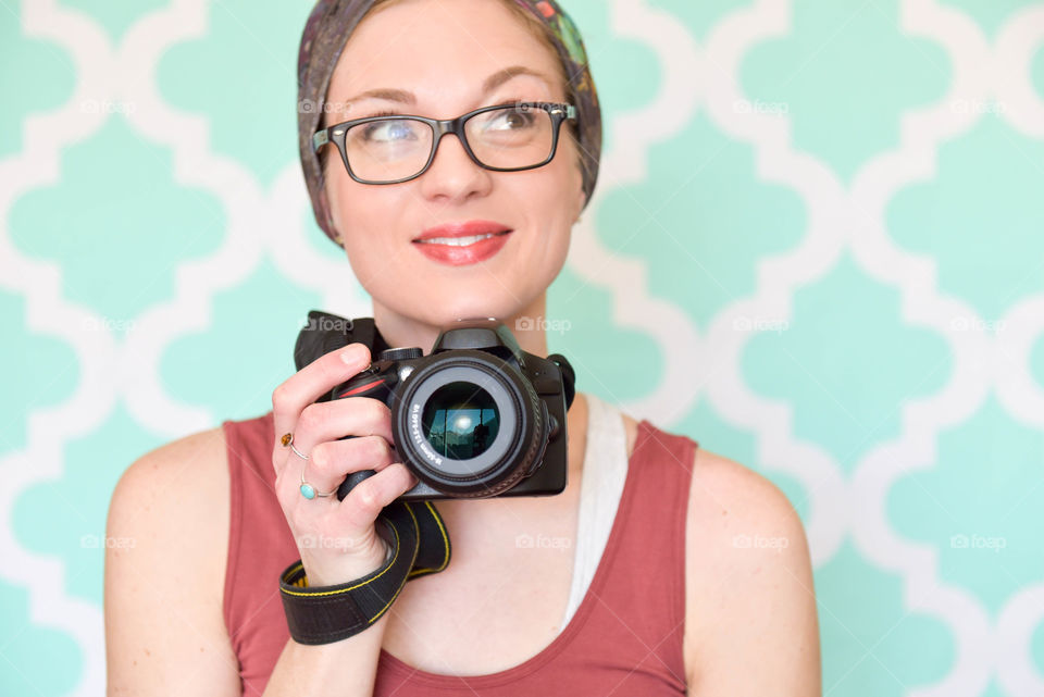 Woman photographer smiling and holding a camera