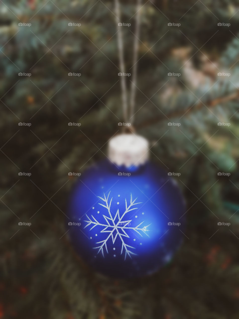 Blue ornament hanging on the Christmas tree.