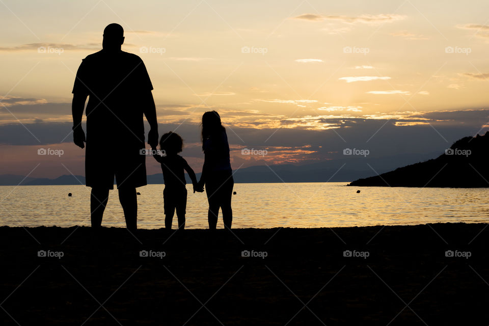 family at sunset. single parent family on beach at sunset