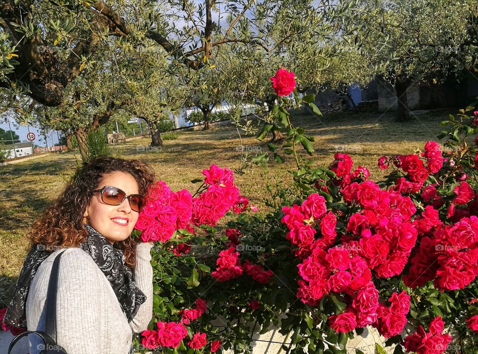 Woman among red roses