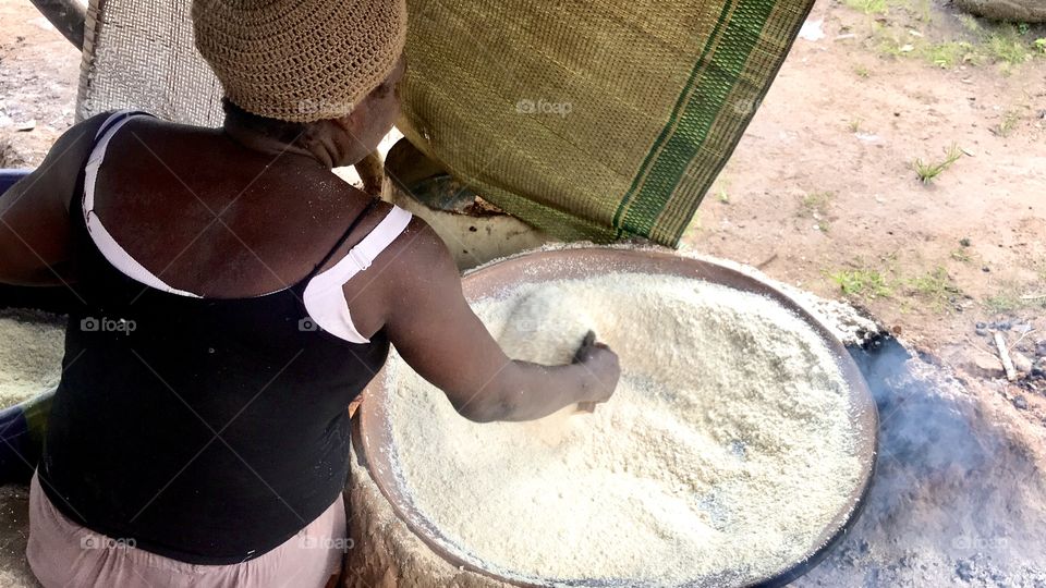 African Yoruba tribe woman making garri with cassava from her village in Ogun State Nigeria 