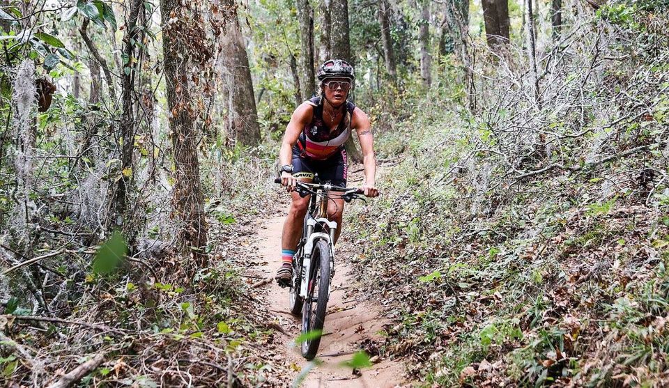 Young woman cycling in forest road