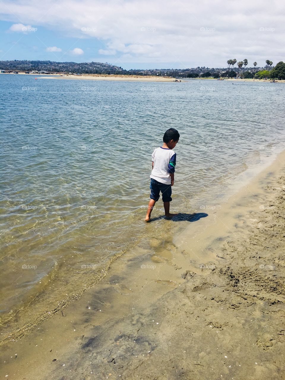 Little boy wading in water