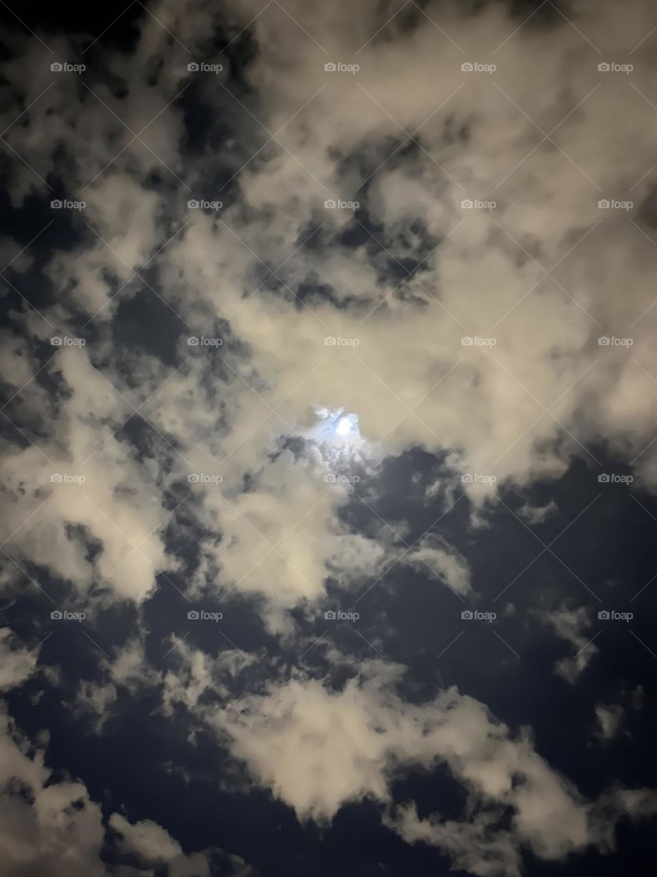 A spooky moon hovers over earth as the clouds shroud what we don’t understand 