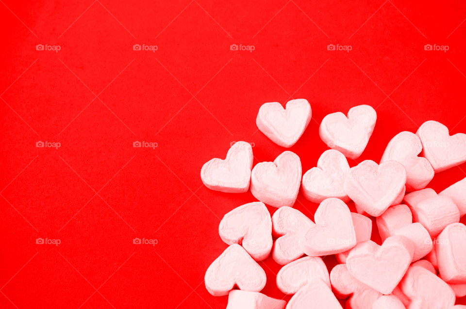 Pink marshmallows on red background 