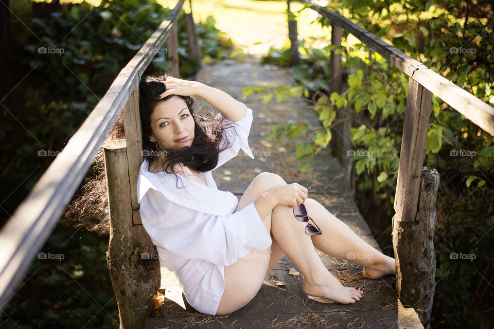 Beautiful woman sitting on footbridge