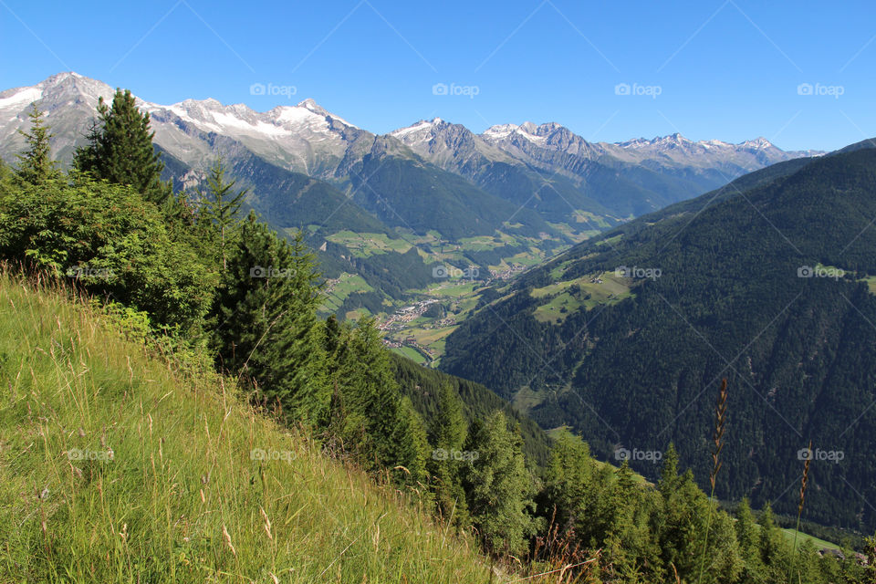 Hiking trail in the mountains, view over valley and mountain peaks with snow