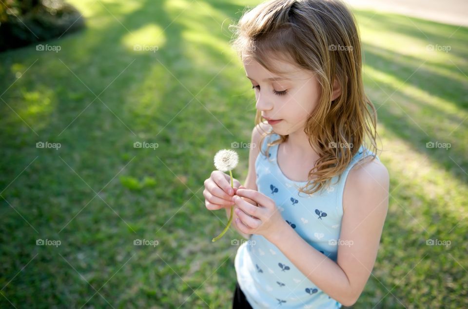 Young girl holding dandelion 