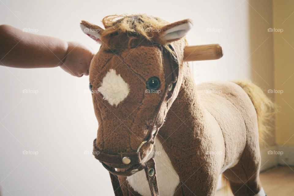 Close-up of a child's hand with rocking horse