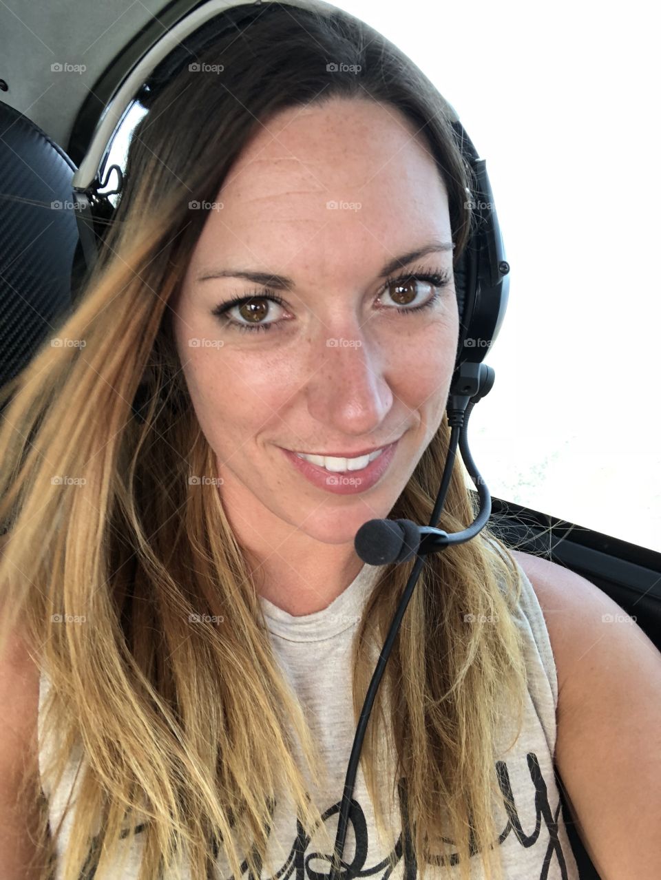 Young woman wearing a headset in an airplane 