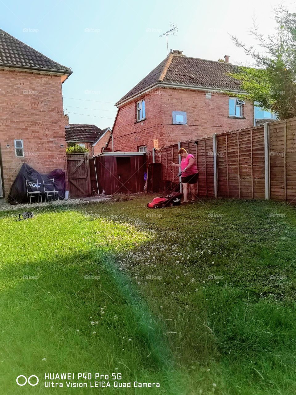 jardín y mujer que corta el césped con una máquina de wilko
