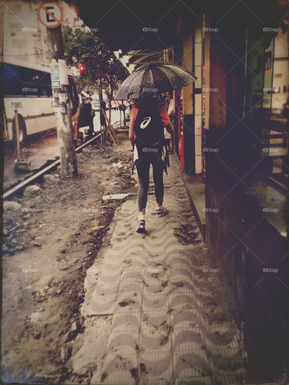 Girl with umbrella on a rainy day in the city streets