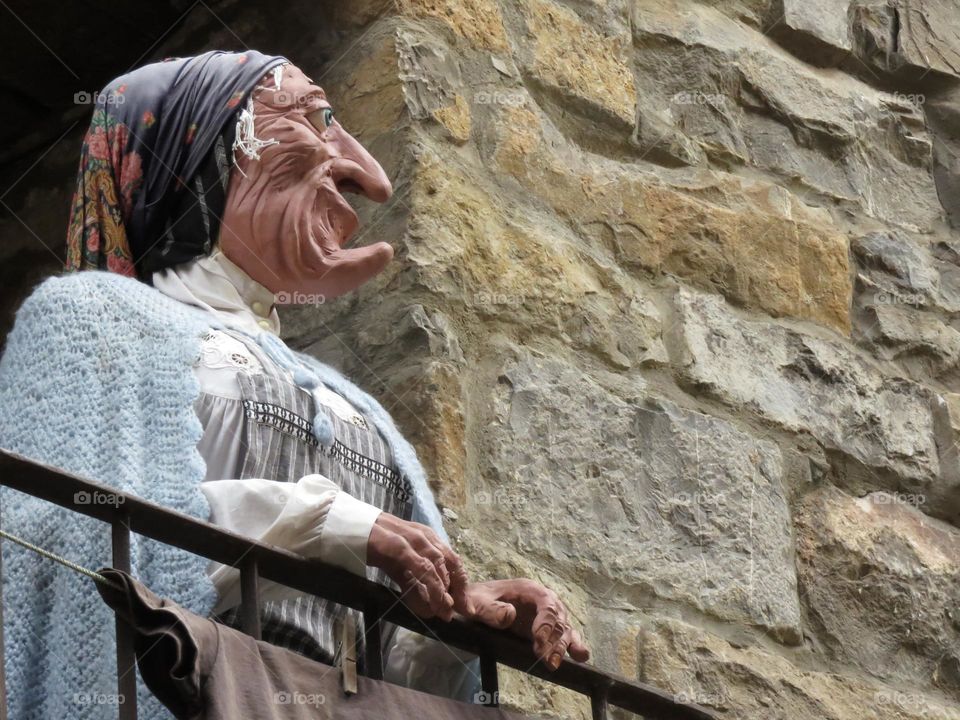 Statue of an old woman on a balcony