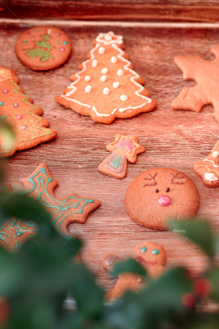 Christmas cookies decorated with frosting on wooden board