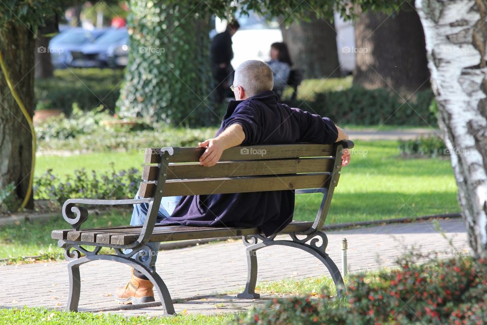 Man relaxing in the park people watching 