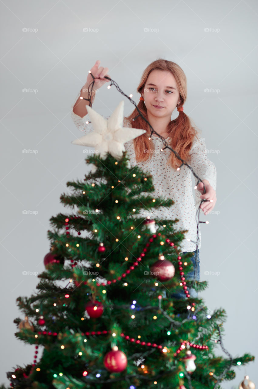 Teenage girl decorating christmas tree