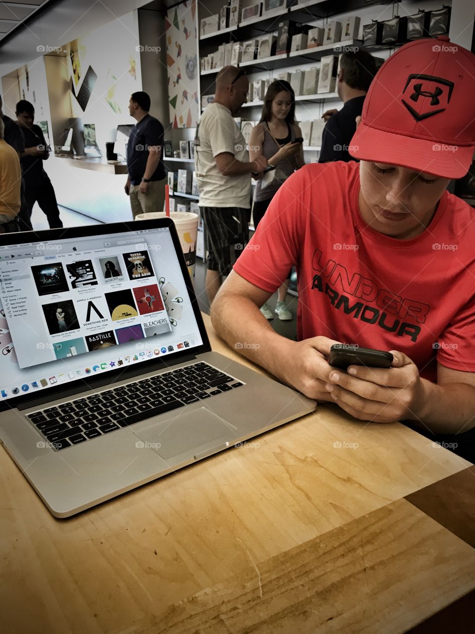 Young man using mobile phone in electronic shop