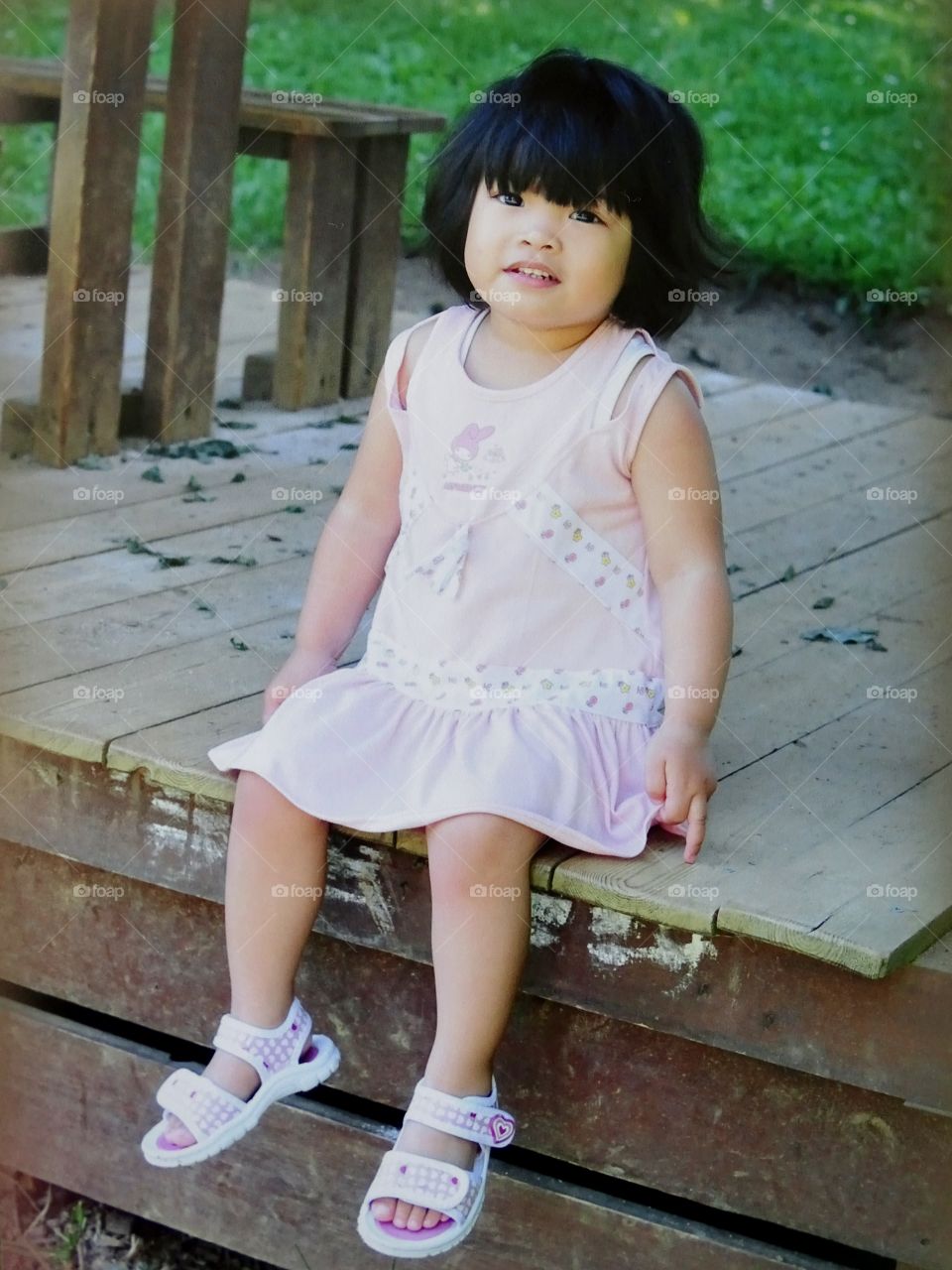 Asian little girl sitting on patio