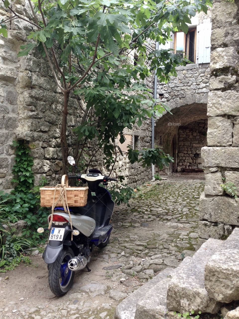 A motorbike standing in. An old French village