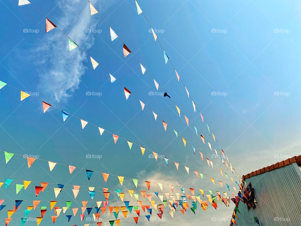 Low angel view of multicolored prayer flags against blue sky in the morning 