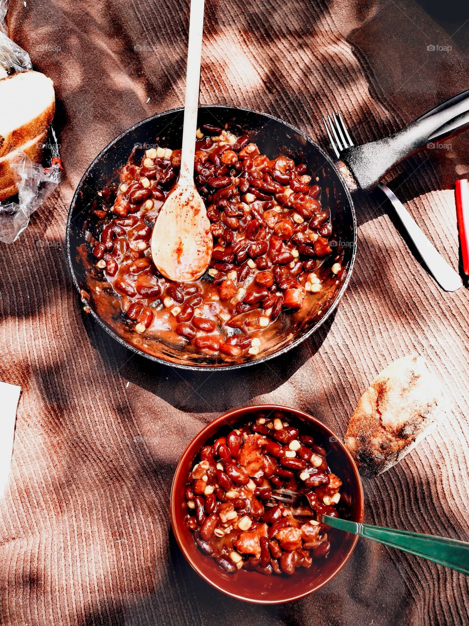 Simple food on fire at picnic, beans with hot sauce