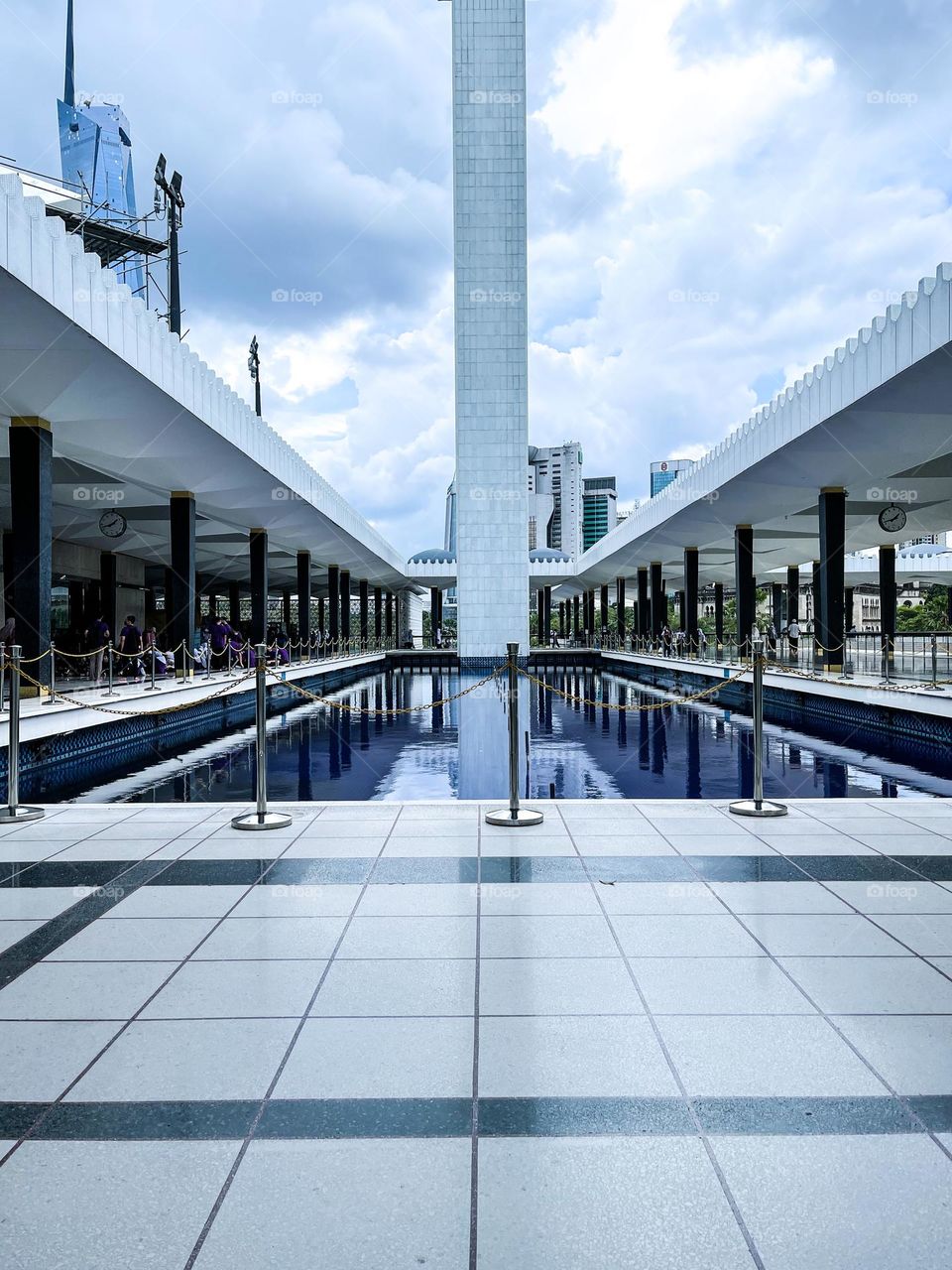 Mosque architecture view inside the walking area with blue pond on the side and minaret at the centre