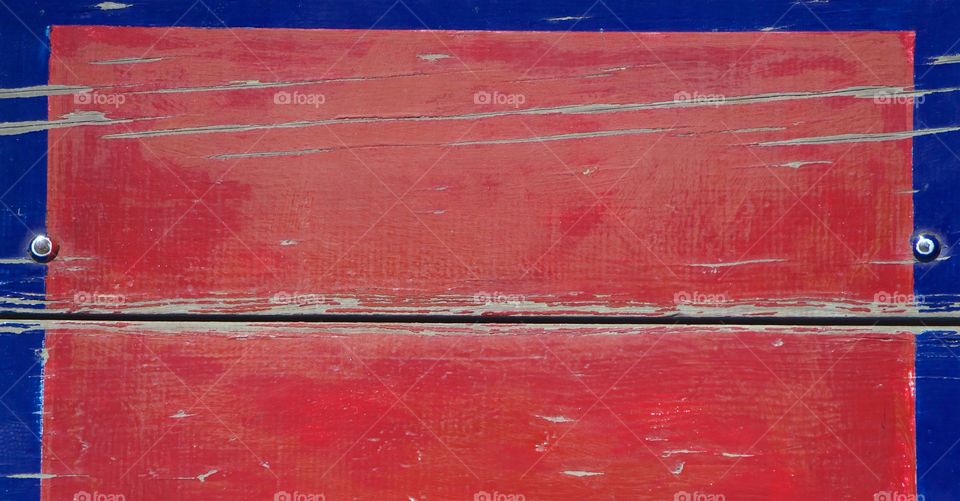 A closeup of a bolted red and blue backboard on an outside park basketball court in a San Miguel de Allende, Mexico.