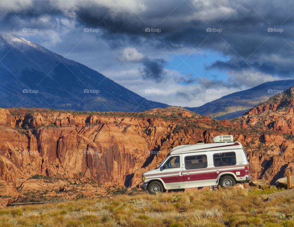 Camper Van in front of red rocks in Utah.