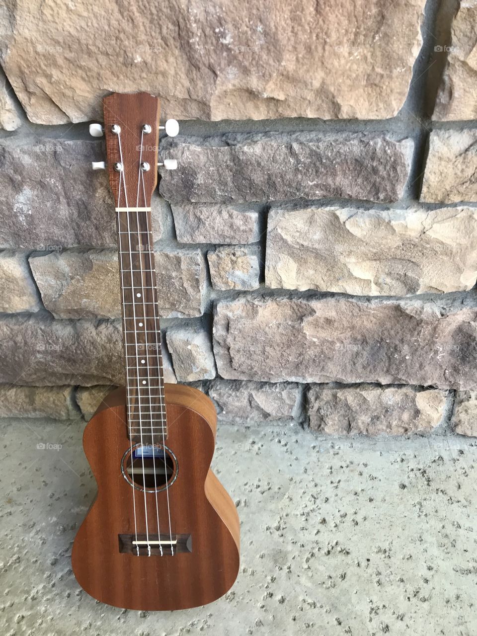 Guitar by brick wall outside - Ukulele