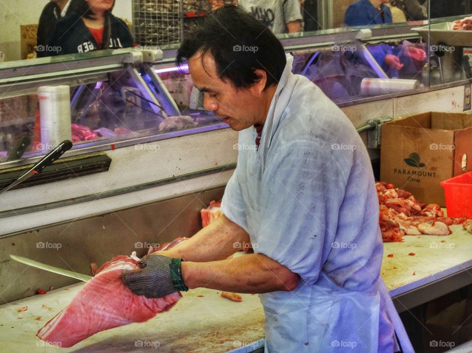 Butch Preparing A Cut Of Red Meat. Butcher In A Chinese Marketplace
