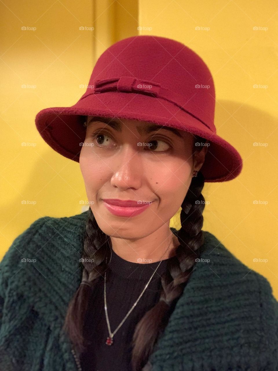 A woman wearing a red hat and green sweater.