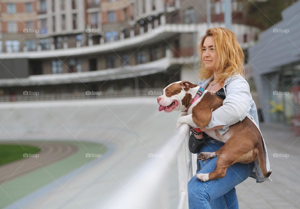 walking the dog down the street, the owner walks the weakling, teaches her, cleans up after her, educates, plays with his pet. people and dogs are best friends