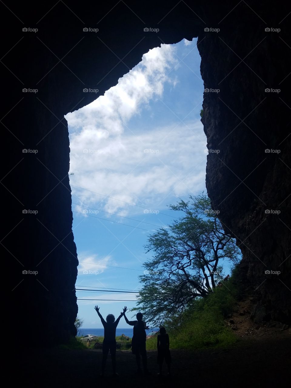 ladies pose in entryway to Makua Cave