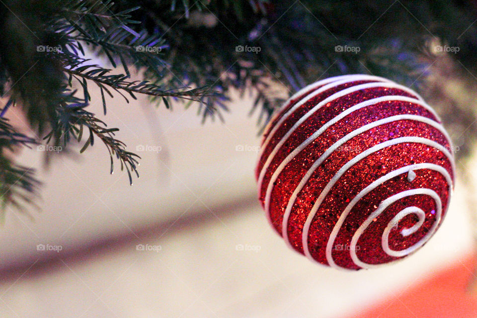 Red Christmas tree ball decoration with white lines and pine branches